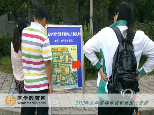 口腔醫(yī)師考生仔細研究醫(yī)師考試現(xiàn)場引導圖