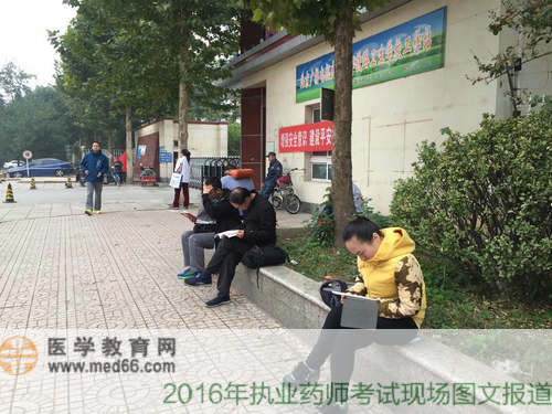 臨近考試，在考場門口抓緊時(shí)間復(fù)習(xí)的考生